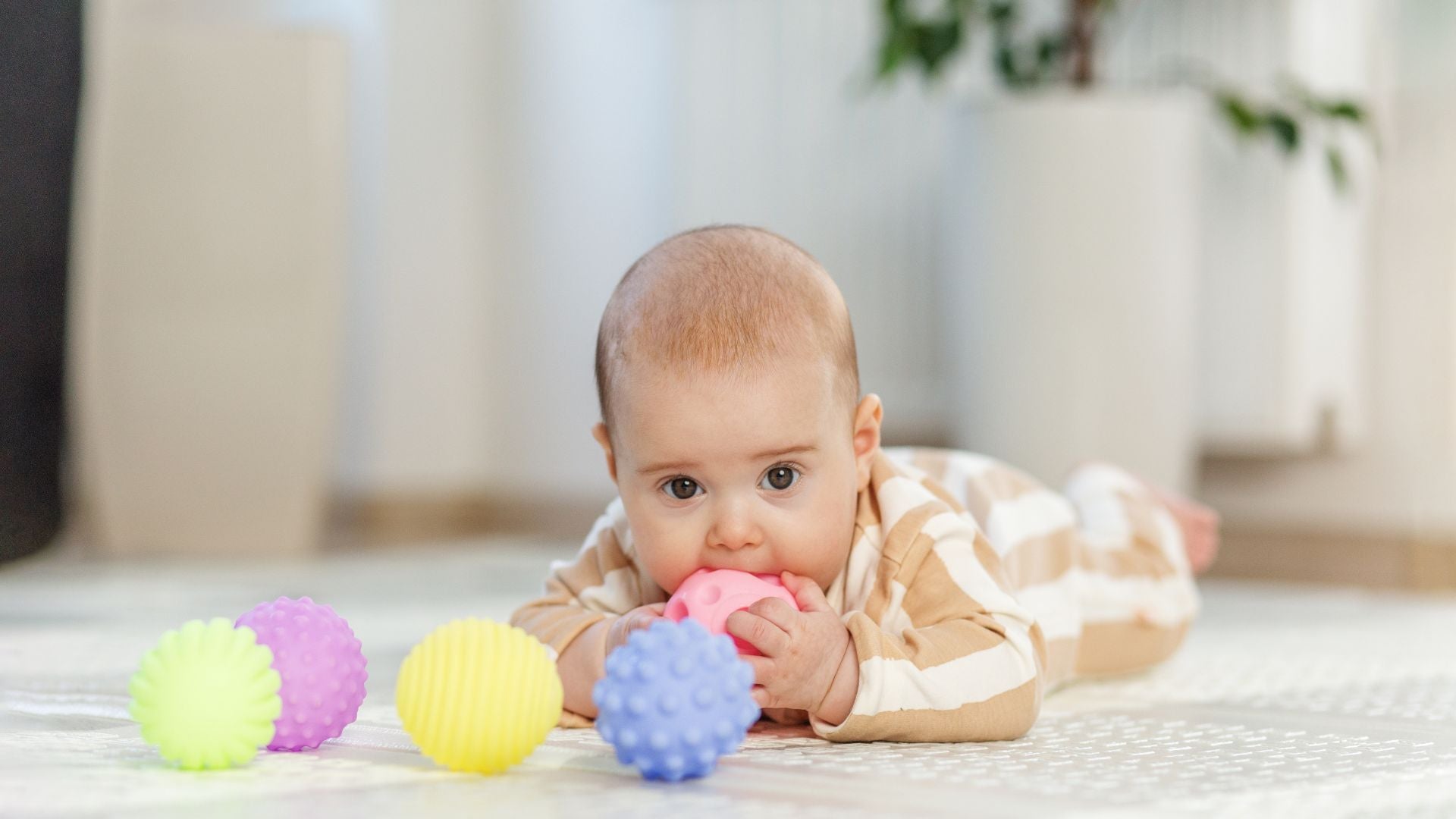Baby reaching and grasping toy at three months, close up of hands