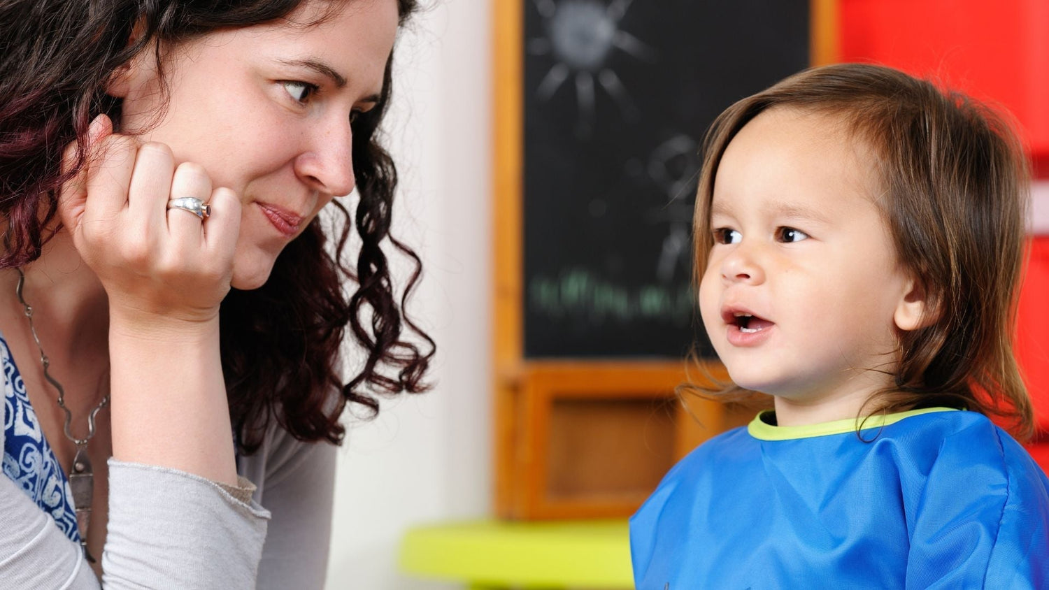 toddler speaking to his mum who is listening attentively