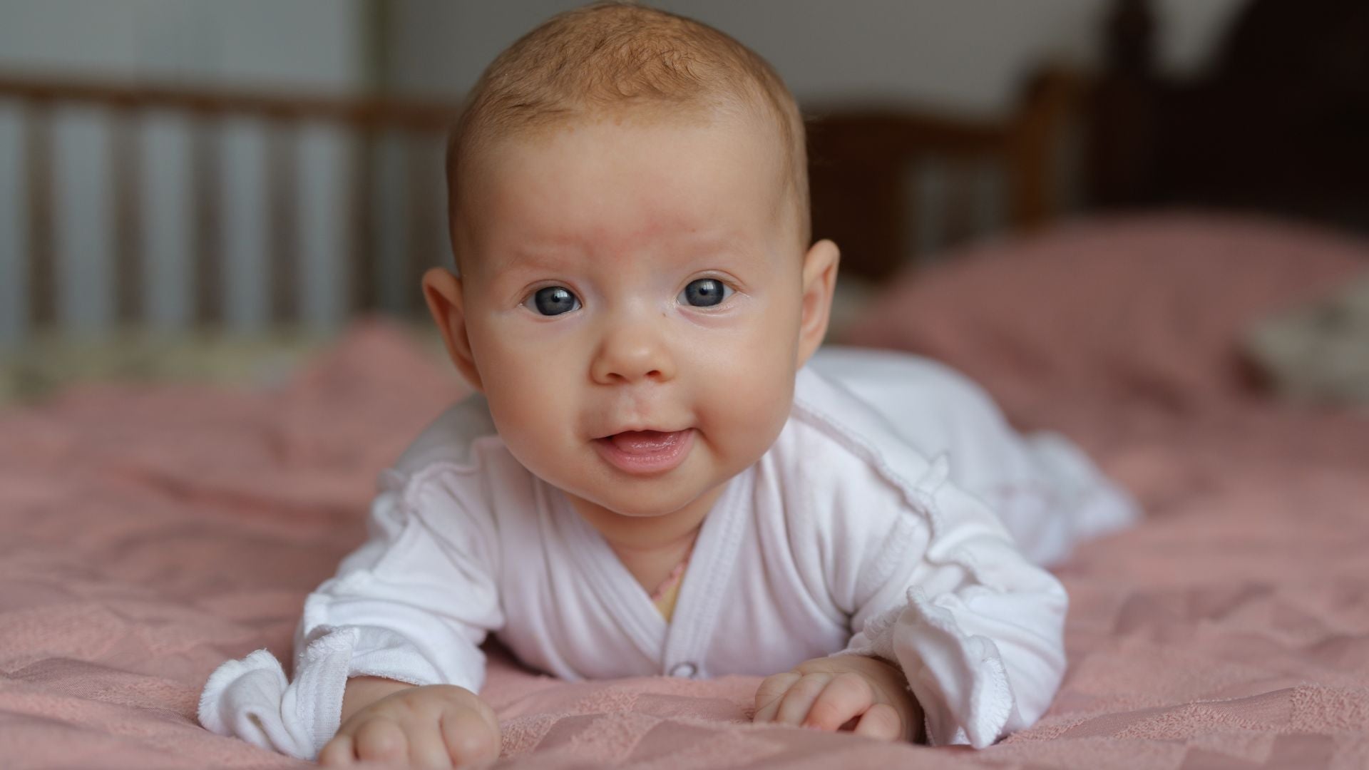 Two month old baby with wide curious eyes, natural light, close up
