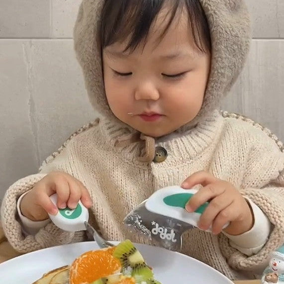Child in bear costume eating a dessert with a fork and knife