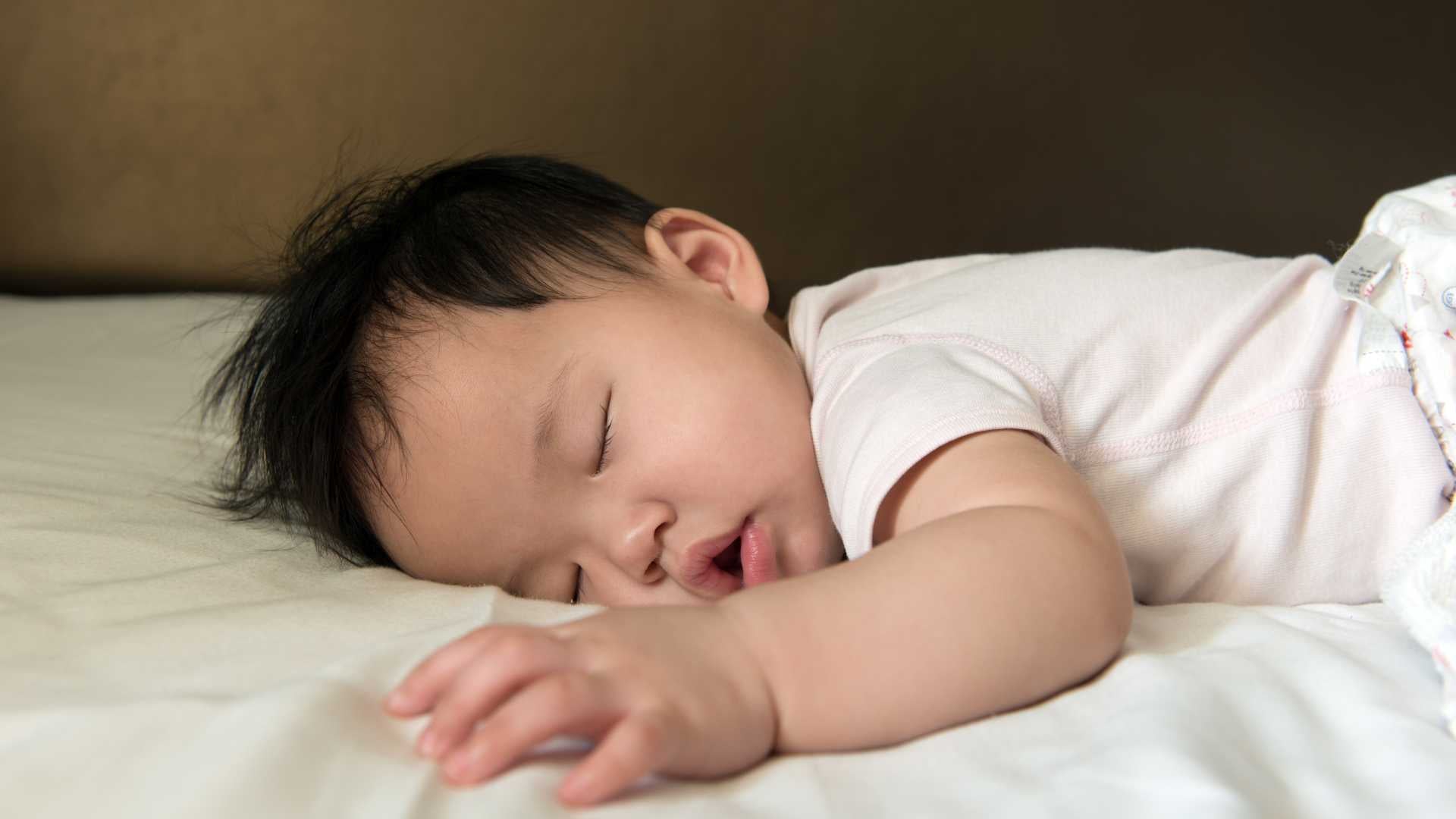 toddler boy fast asleep in bed