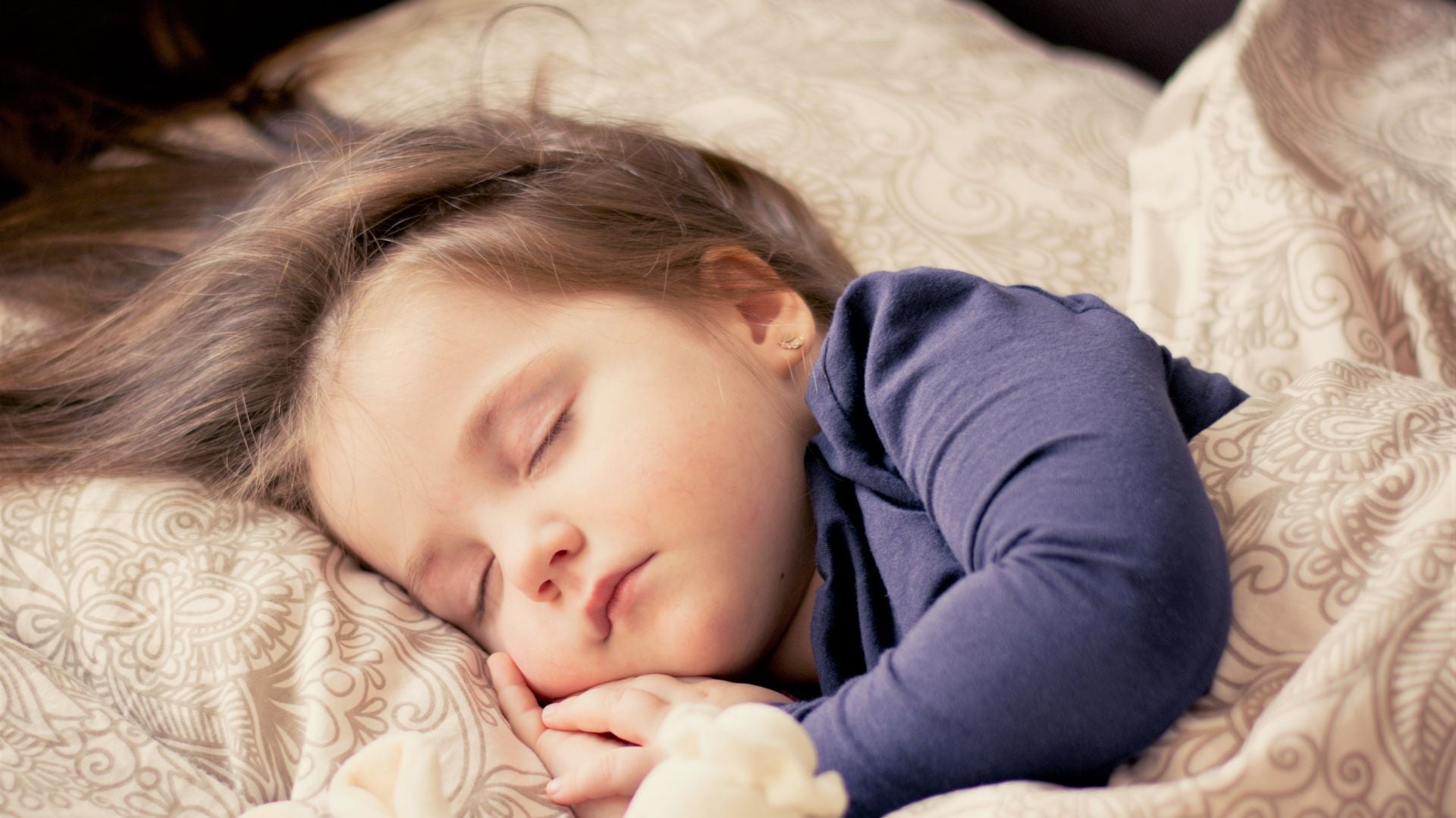 toddler peacefully asleep in bed