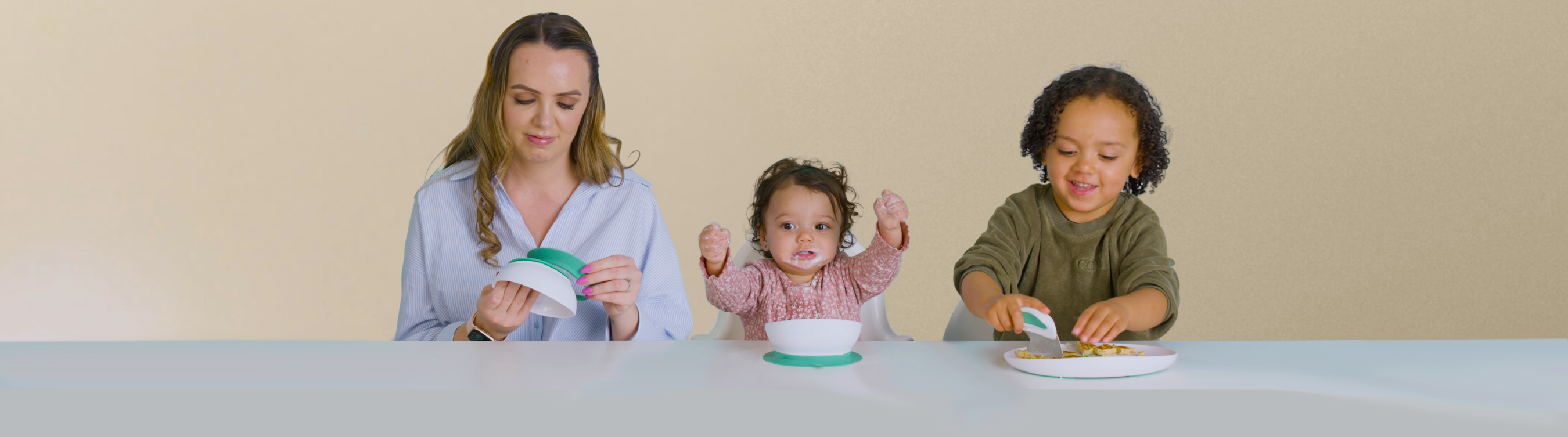 Woman and two children sitting at a table with doddl plates and doddl bowls.