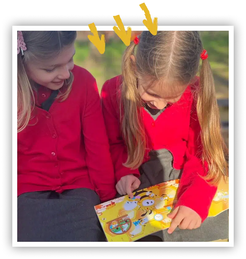 Two schoolchildren reading together in class