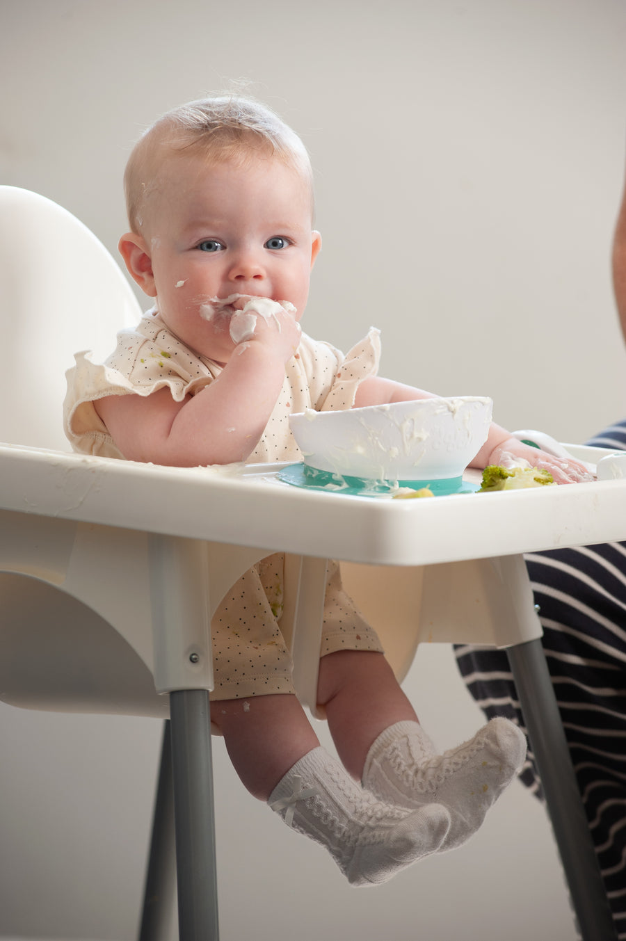 A baby self-feeding at six months