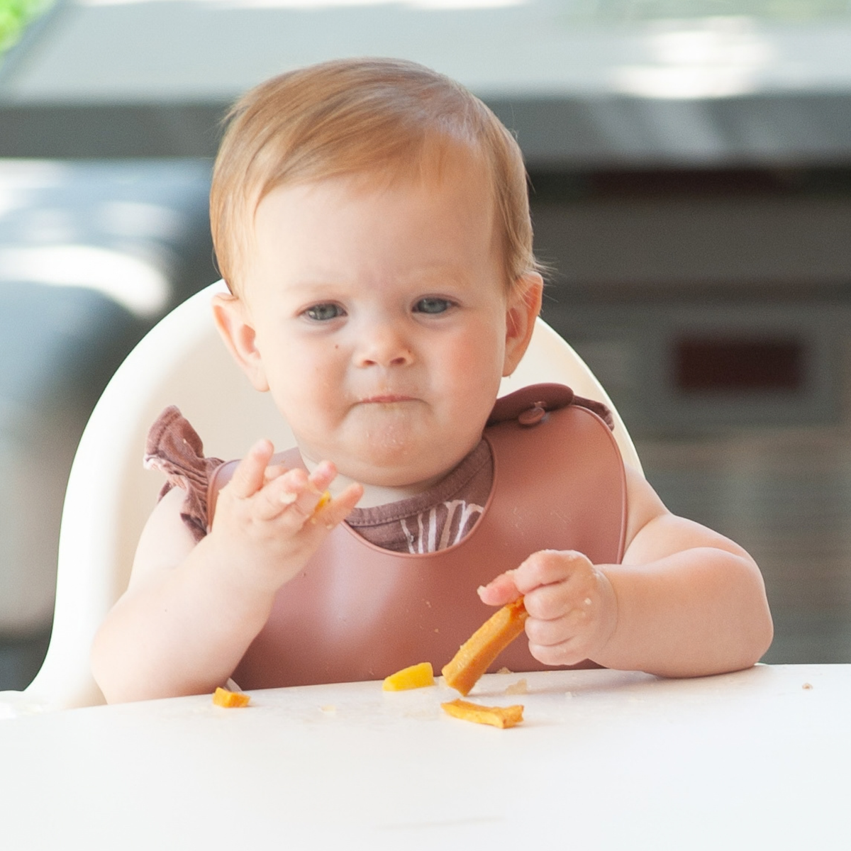 A baby self-feeding at six months