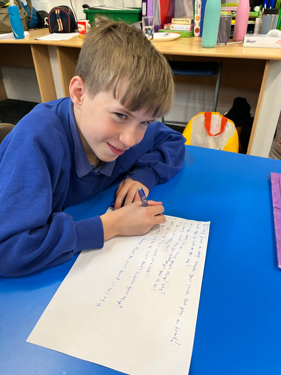 Schoolboy writing at a classroom desk