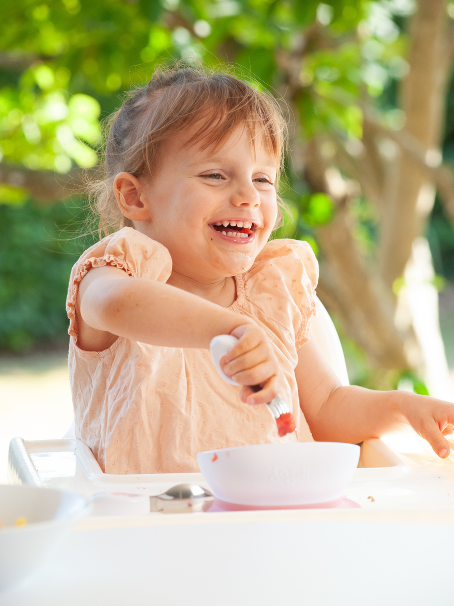 A child self-feeding at their own pace