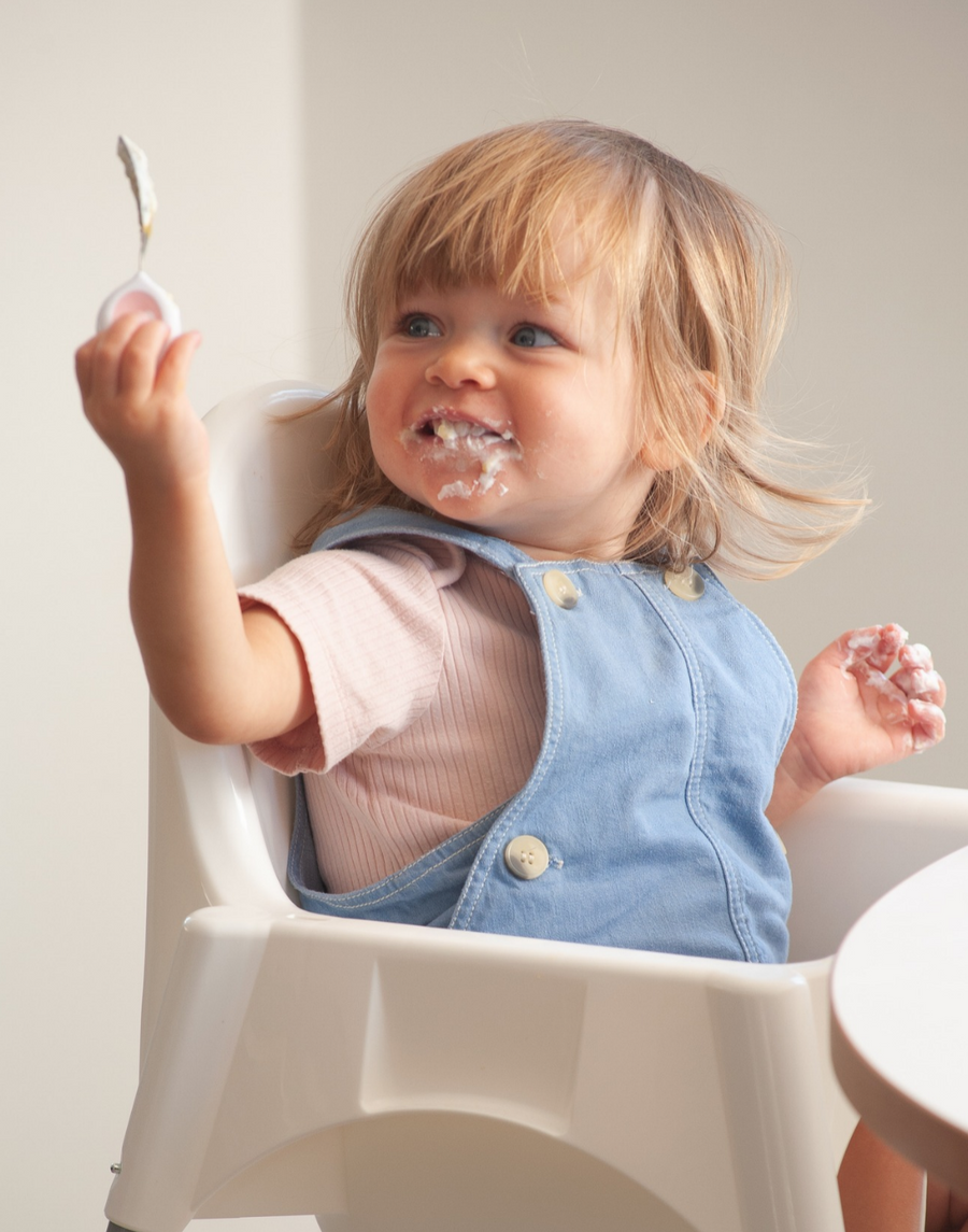 A toddler eating confidently