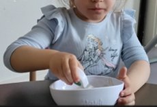A child scooping from a doddl bowl at a COGEHAM nursery